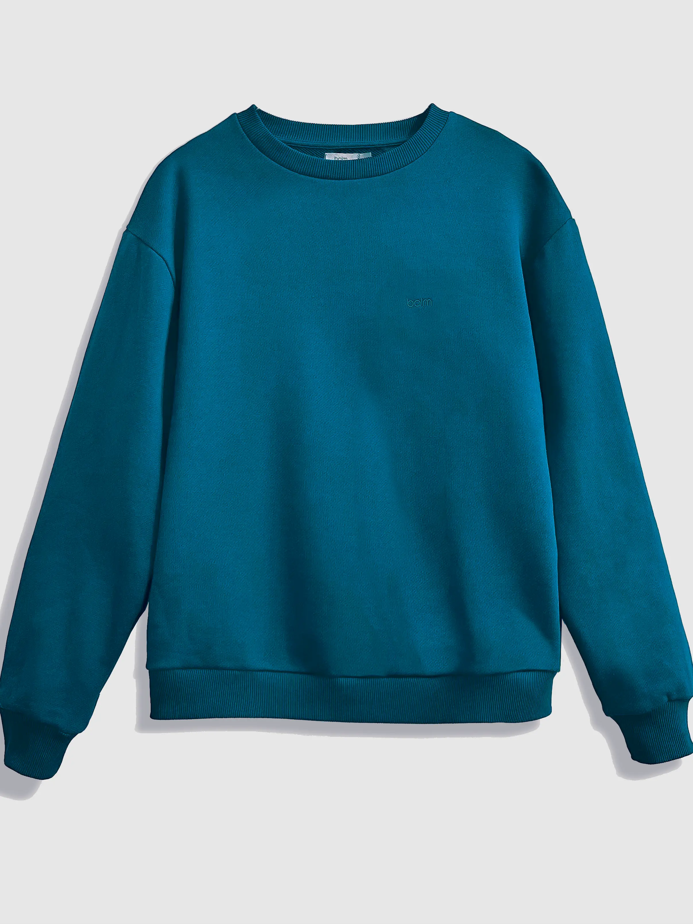 Close-up of a single green leaf against a white background.