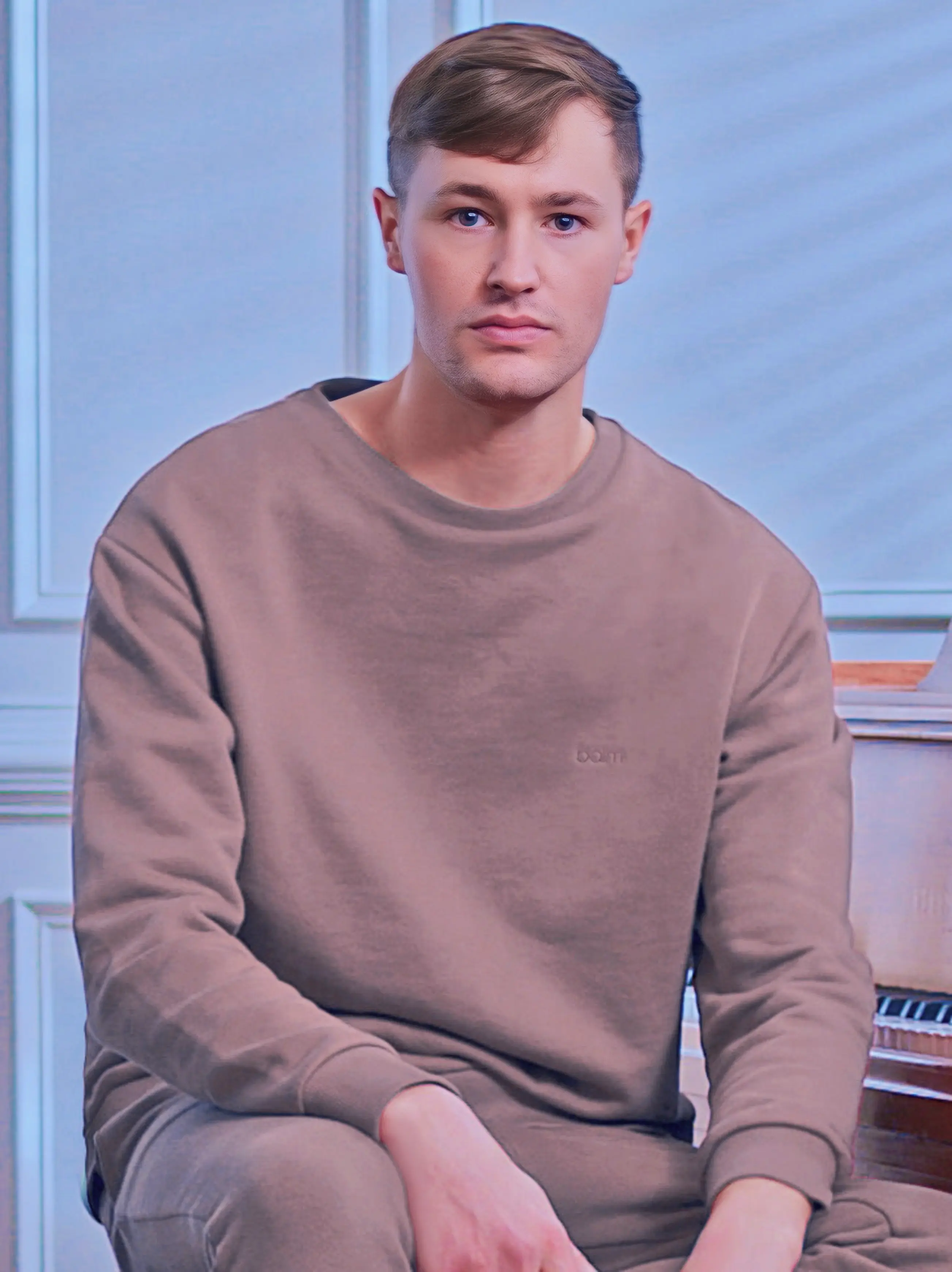 Cream-colored hoodie on a wood-textured background.