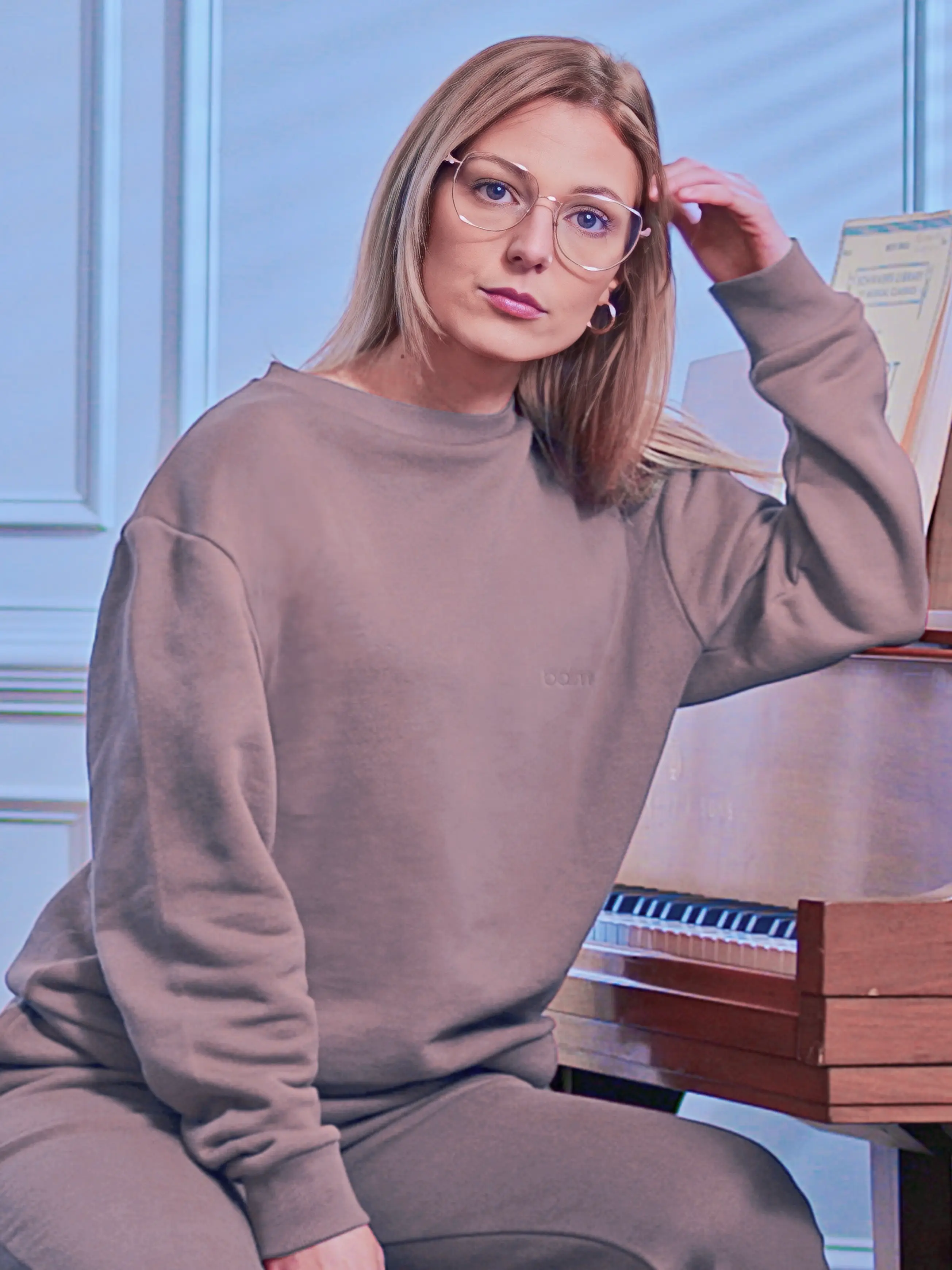 Cream-colored hoodie on a wood-textured background.