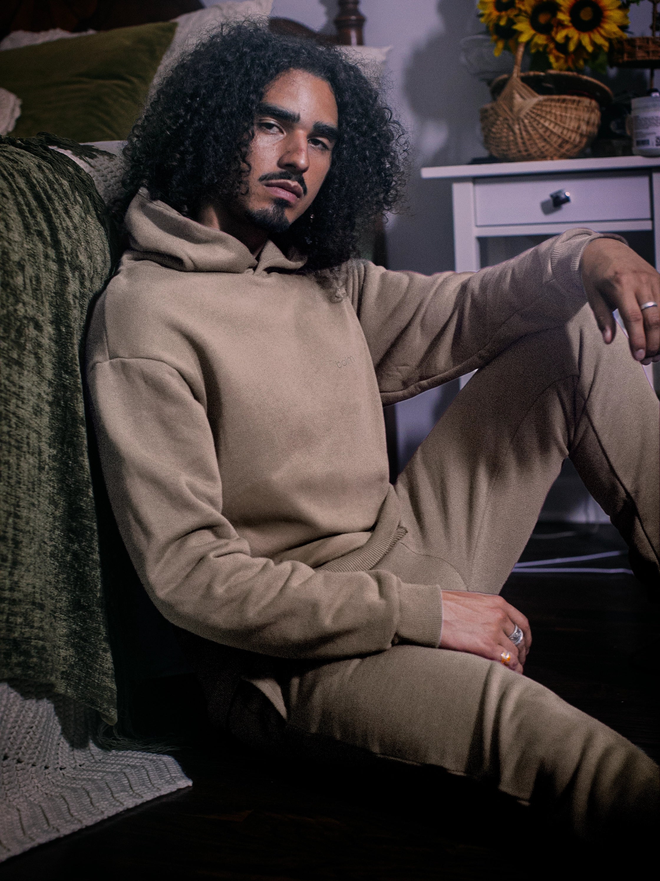 Cream-colored hoodie on a wood-textured background.