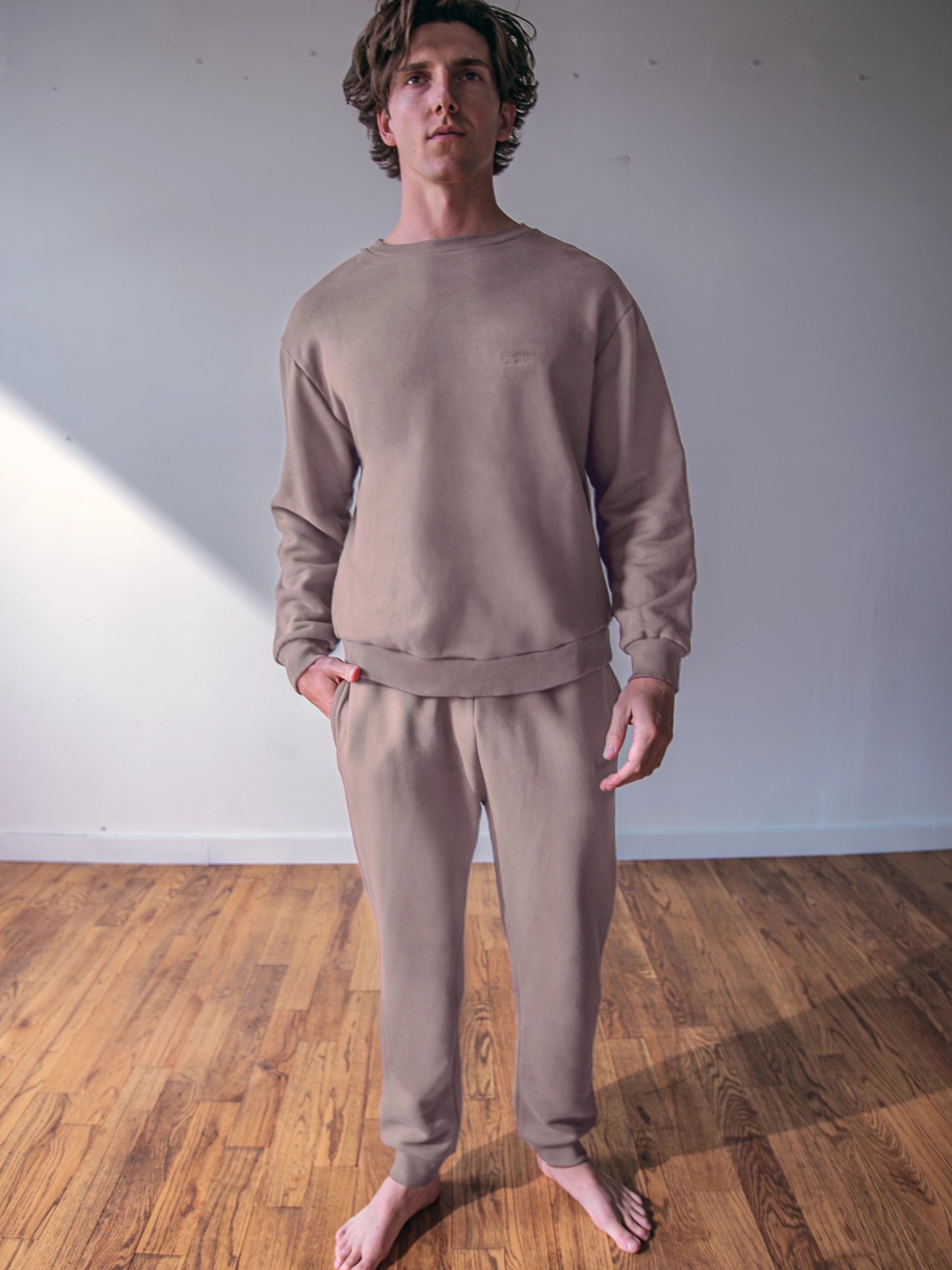 Cream-colored hoodie on a wood-textured background.