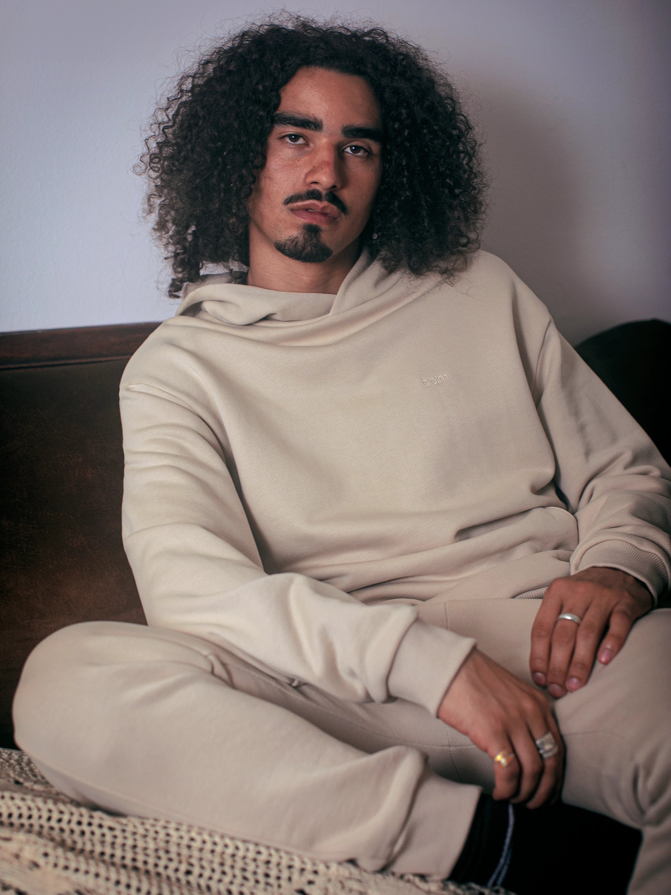 Cream-colored hoodie on a wood-textured background.