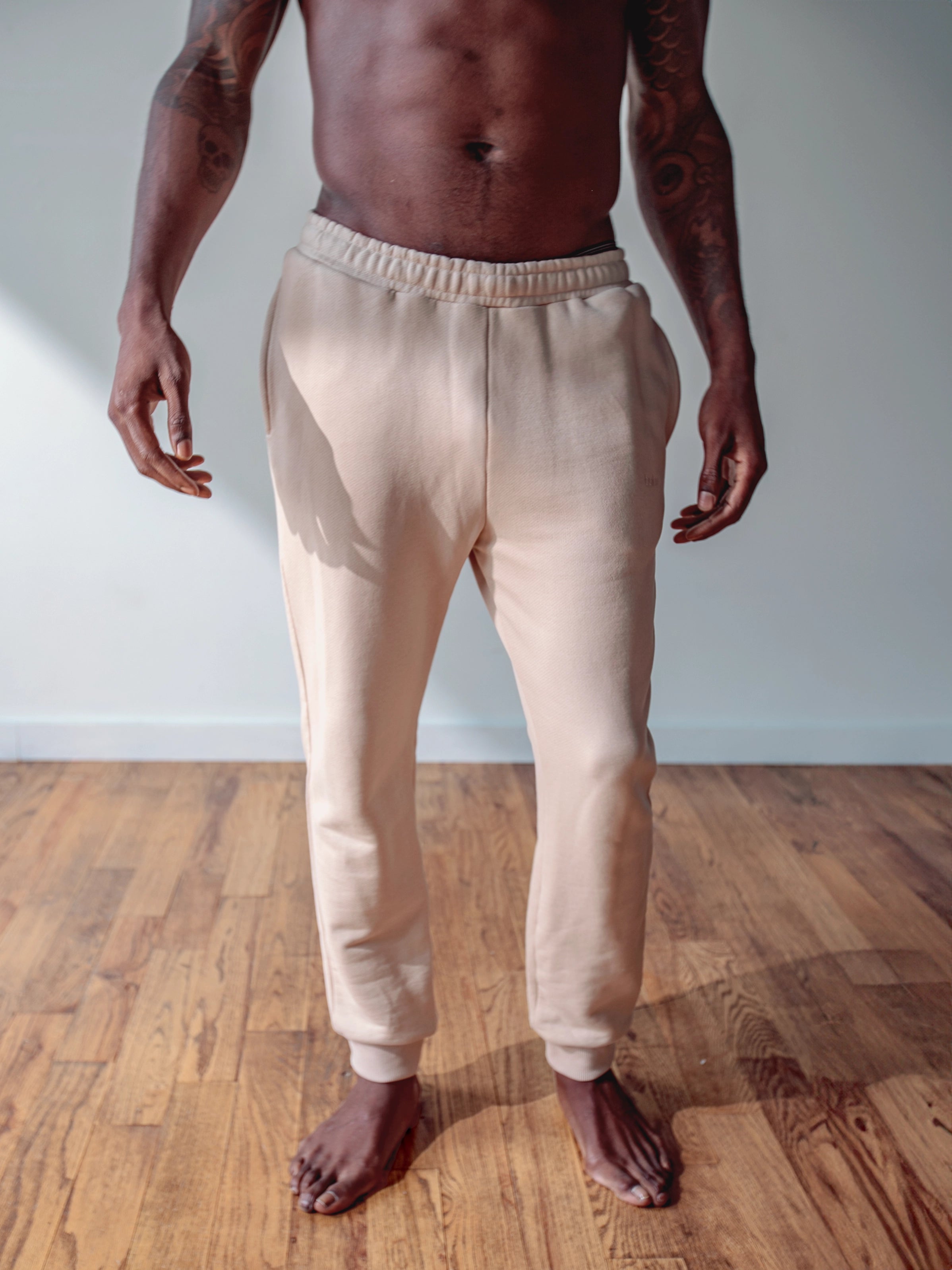 Cream-colored hoodie on a wood-textured background.