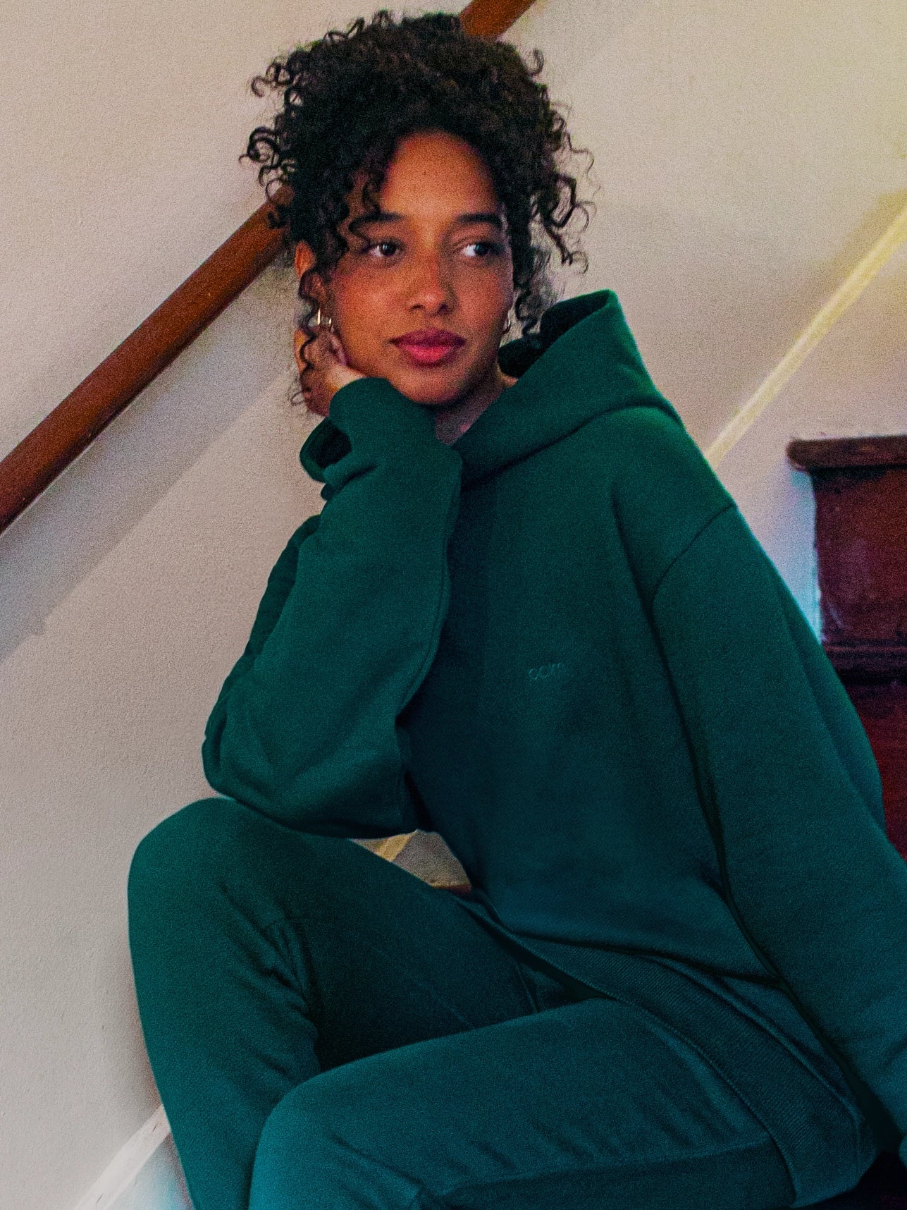 Cream-colored hoodie on a wood-textured background.