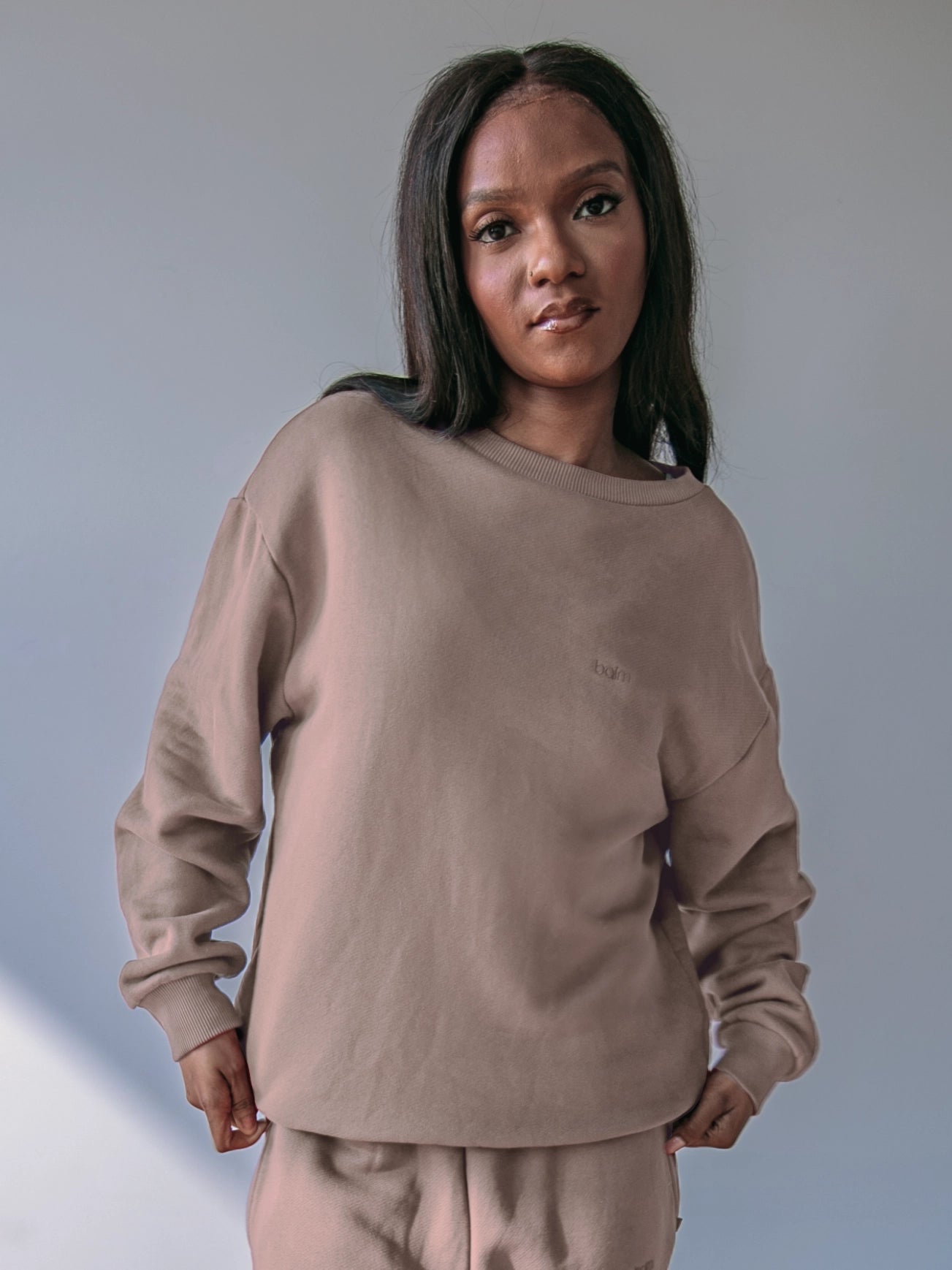 Cream-colored hoodie on a wood-textured background.